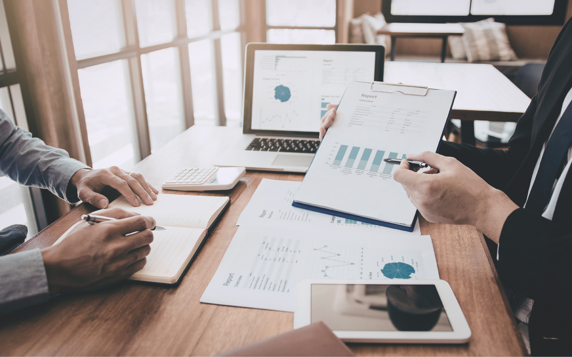 Real estate investors reviewing financial reports and charts during a commercial loan strategy meeting